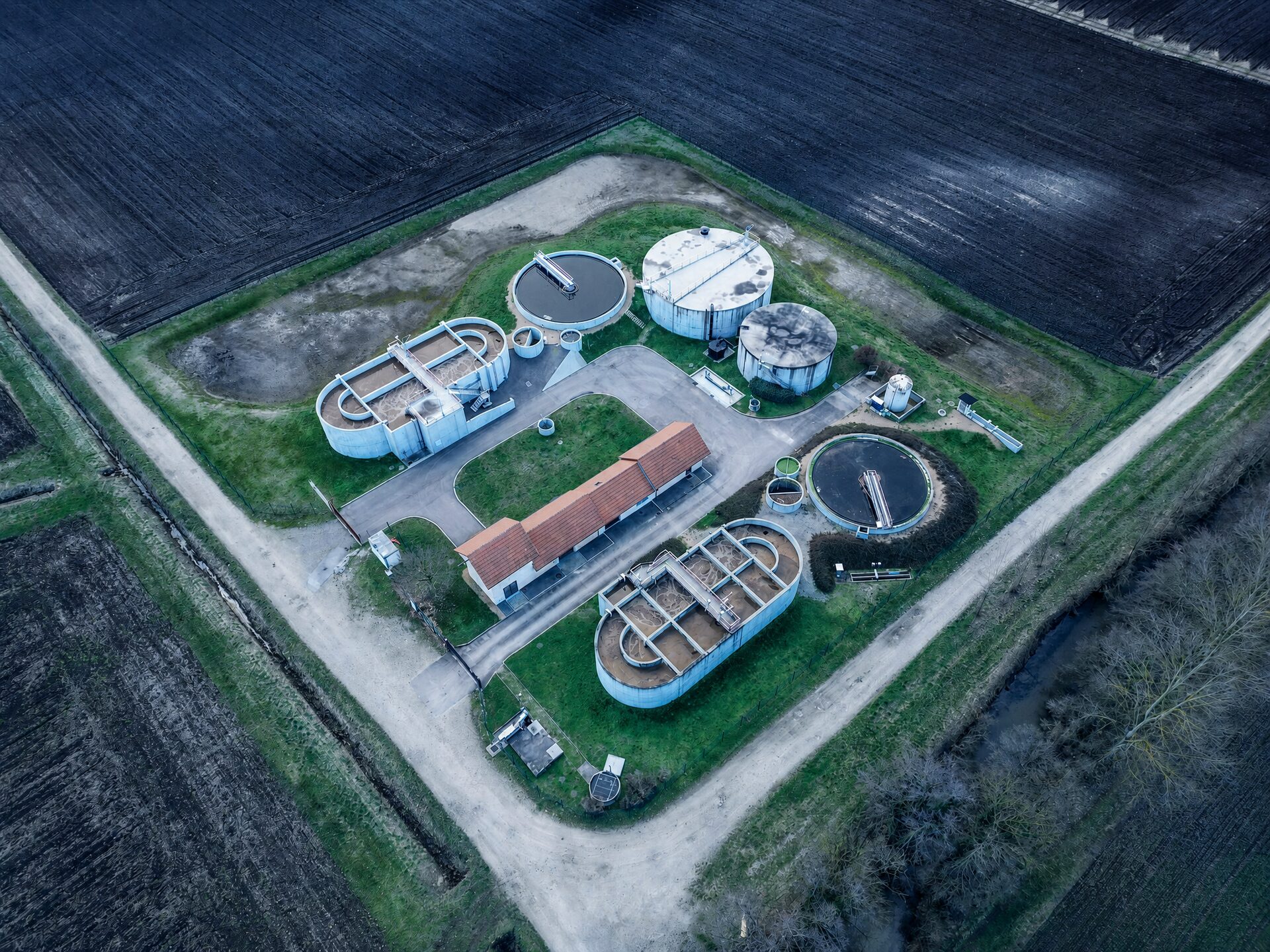 Aerial overview of a secondary wastewater treatment plant with activated sludge basins, secondary clarifiers and sludge digesters